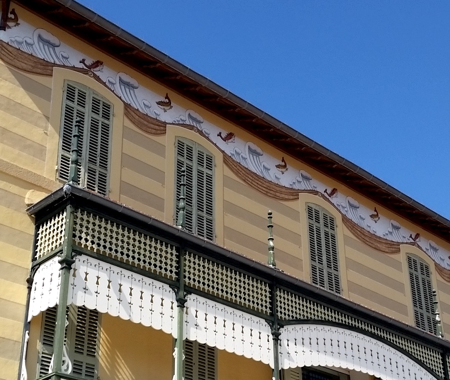 Pale-green window shutters, plus wave and whale murals, in Cassis